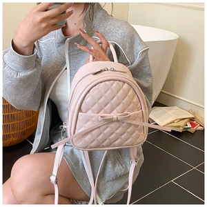 Sac à dos rose matelassé avec nœud présenté dans un cadre de vie décontracté