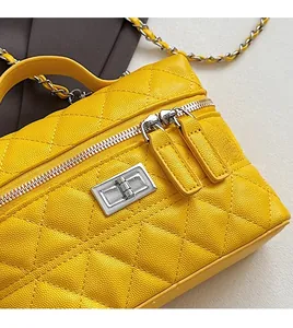 Détail du sac en cuir matelassé jaune avec fermoir métallique argenté et chaîne