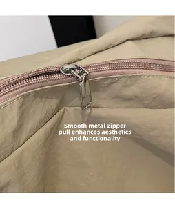 Détail de la fermeture éclair en métal argenté poli sur un sac à bandoulière en nylon