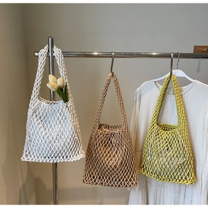 Detail of woven mesh bucket bags in white, beige and lime green with drawstring liners