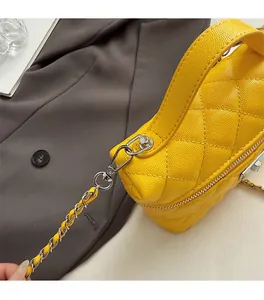 Détail du sac à main en cuir caviar jaune avec surpiqûres losanges et fermoir argenté