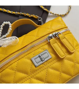 Détail de sac à main en cuir matelassé jaune avec fermoir argenté et double fermeture