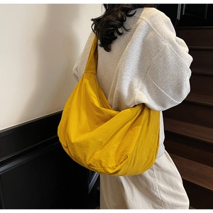 Gros plan du sac croissant en nylon jaune vif montrant le tissu texturé et sa capacité