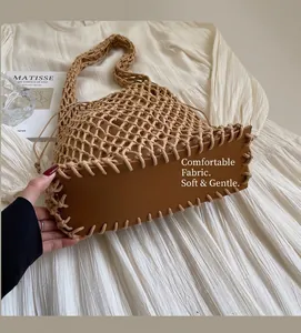 Close-up of khaki woven crochet tote bag featuring a sturdy brown leather base for support