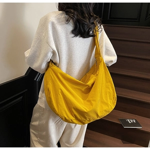 Gros plan sur le sac bandoulière en nylon jaune avec fermeture éclair métallique