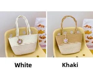 Detail view of woven cotton rope bucket bags with floral charms in white and khaki colors