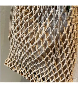 Detail of light brown woven mesh bucket bag with drawstring closure and fabric lining