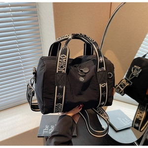 Dettaglio della borsa a cilindro in nylon nero con nastro UCHAO e doppia cerniera