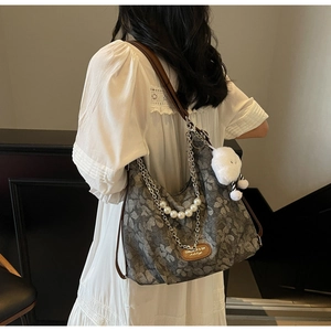 Detail of floral tote bag with pearl chain and white plush cloud charm accessory