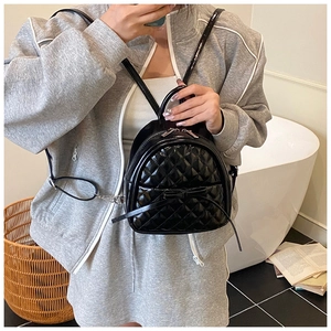 Mini sac à dos noir matelassé avec nœud porté par un mannequin dans un cadre intérieur