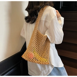 Close-up of woven net bucket bag filled with fresh fruit showing large storage capacity