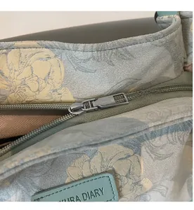 Detailed close-up of smooth zipper closure and floral pattern on large tote bag