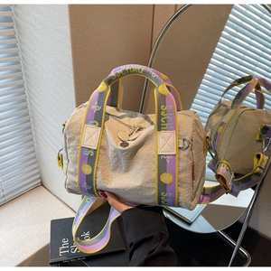 Dettaglio della borsa tote in nylon beige con spalline intrecciate SJCH e riflesso