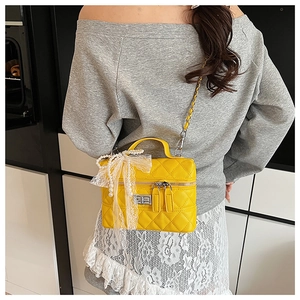 Sac bandoulière matelassé jaune avec nœud en dentelle perle porté par un mannequin