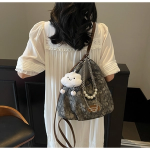 Détail du sac cabas floral avec chaîne en perles et breloque nuage sur la bandoulière