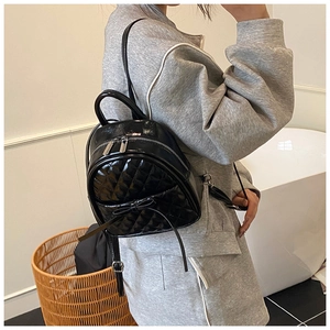 Mini sac à dos noir matelassé avec nœud et fermeture éclair porté par un mannequin