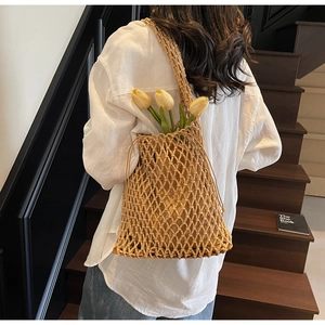 Chic woven shoulder bucket bag with hollow mesh pattern shown in an aesthetic lifestyle setting