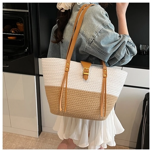 Dettaglio della borsa tote intrecciata a mano con design bicolore e manici in pelle
