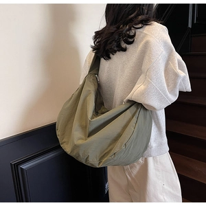 Détail du sac bandoulière en nylon vert olive avec fermeture éclair et sangle réglable