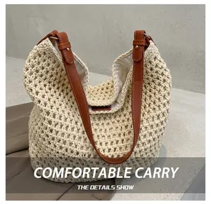 Detail of hand-woven straw bucket bag featuring brown leather handle and gold metal buckles