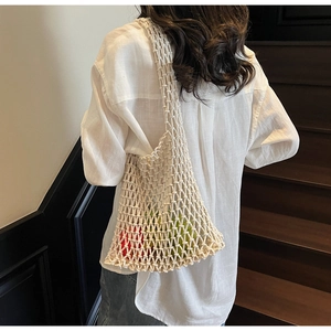 Detail of hand-woven cream bucket bag with hollow mesh texture and large capacity