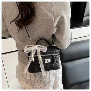 Détail du sac bandoulière matelassé noir avec nœud en dentelle perlée et fermoir argent