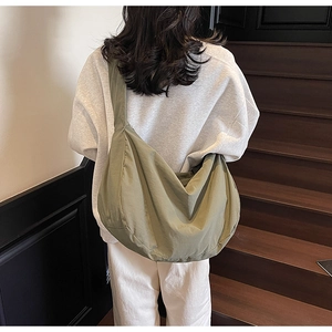 Sac bandoulière en nylon vert olive style tote spacieux porté par un mannequin de dos