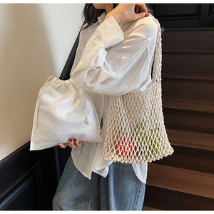 Detail of white hand-woven mesh bucket bag with a cotton drawstring inner liner