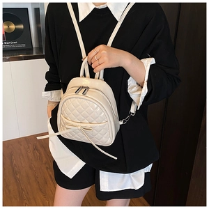 Détail du mini sac à dos matelassé crème avec nœud décoratif et fermeture éclair