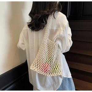 Close-up of a white hand-woven mesh bucket bag showing detailed texture and large capacity