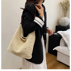 Detail of hand-woven off-white mesh shoulder bag with brown leather strap contrast