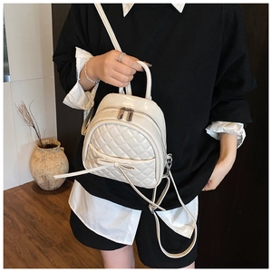Sac à dos matelassé blanc avec nœud porté par un mannequin dans un décor intérieur