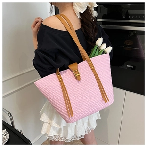 Dettaglio della borsa tote rosa intrecciata a mano con spalline in pelle marrone e fibbia