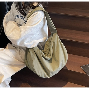 Photo de style de vie du grand sac croissant en nylon vert olive pour les trajets quotidiens