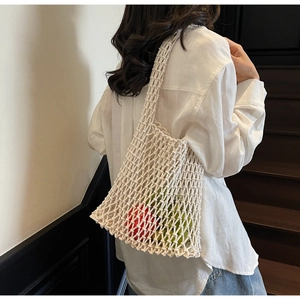 Detail of white woven bucket bag showing hollow mesh texture and large capacity
