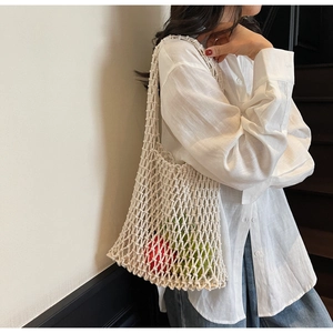 Detail of white hollow woven tote bag showing large capacity with apples inside