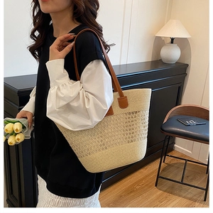 Dettaglio della borsa tote in paglia intrecciata con spalline in pelle marrone per il mare