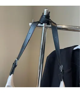 Detail of adjustable black leather shoulder strap with silver buckle on white tote bag