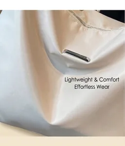 Detail of white satin fabric with silver metal zipper on a stylish crossbody tote bag