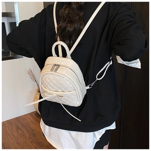 Mini sac à dos matelassé beige avec nœud, porté par un mannequin sous un angle de 45 degrés