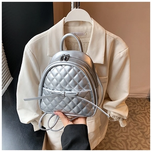 Détail du mini sac à dos argenté matelassé avec nœud et double fermeture éclair