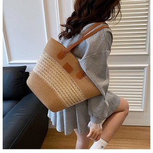 Dettaglio della borsa tote in paglia intrecciata con patch e manici in pelle marrone