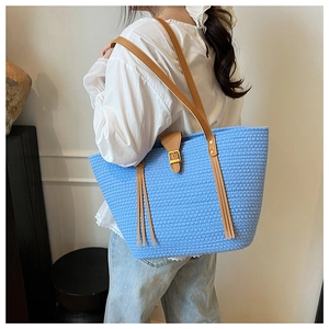 Dettaglio ravvicinato della borsa tote intrecciata azzurra con tracolla in pelle
