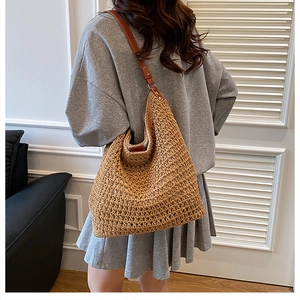 Detail of woven straw tote bag texture and leather strap in a casual lifestyle setting