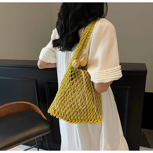 Detail of hand-woven bright yellow hollow out bucket bag with creamy white drawstring cord