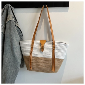 Dettaglio borsa shopper intrecciata bicolore con tracolla in pelle marrone e nappa decorativa