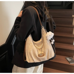 Détail du sac cabas en toile blanc cassé avec chaîne perlée et bandoulière brune