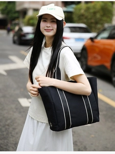 Minimalist black canvas tote bag with white webbing straps and sun embroidery