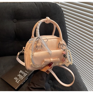 Detail of pink bow bag with lace trim, pearl chain and checkered scarf handle
