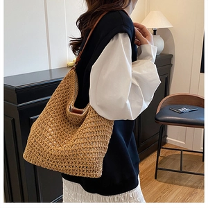 Detail of hand-woven straw shoulder bag with durable brown leather strap for travel